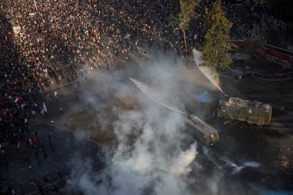 Manifestantes são atingidos por um canhão de água da polícia durante um protesto contra o Governo em Santiago, Chile, na sexta-feira 1 de novembro de 2019. 