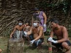 Satere-mawe indigenous people are seen using a smartphone to contact a doctor in Sao Paulo state to receive medical guidance amid the COVID-19 novel coronavirus pandemic at the Sahu-Ape community, 80 km of Manaus, Amazonas State, Brazil, on May 5, 2020. - The Brazilian state of Amazonas, home to most of the country's indigenous people, is one of the regions worst affected by the pandemic, with more than 500 deaths to date according to the health ministry. (Photo by RICARDO OLIVEIRA / AFP)