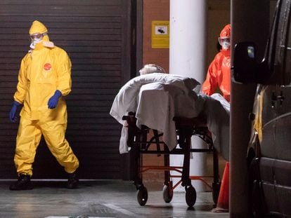 Enfermeiros do serviço de saúde de Múrcia, na Espanha, transferem um homem de uma casa de repouso para o hospital.