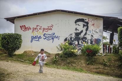 Uma criança corre próximo a mural em La Fila, no município de Icononzo.