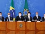 El presidente brasileño, Jair Bolsonaro (al centro), ofrece una conferencia de prensa sobre el nuevo virus que afecta al mundo en el Palacio de Planalto en Brasilia, en Brasil, acompañado de su gabinete. Todos usan mascarillas para protegerse de la pandemia.