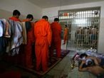 Iraqi prisoners pray inside their cell in the Abu Ghraib prison on the outskirts of Baghdad, Iraq Saturday, July 10, 2004. The infamous prison, which contains some 1,200 inmates suspected or convicted of crimes, was delivered into Iraqi hands in June as part of the transfer of sovereignty to the new Iraqi government. Adjacent to the prison but within the same Abu Ghraib compound, American soldiers have constructed a tent city housing thousands more detainees accused of insurgent activity.(AP Photo/John Moore)