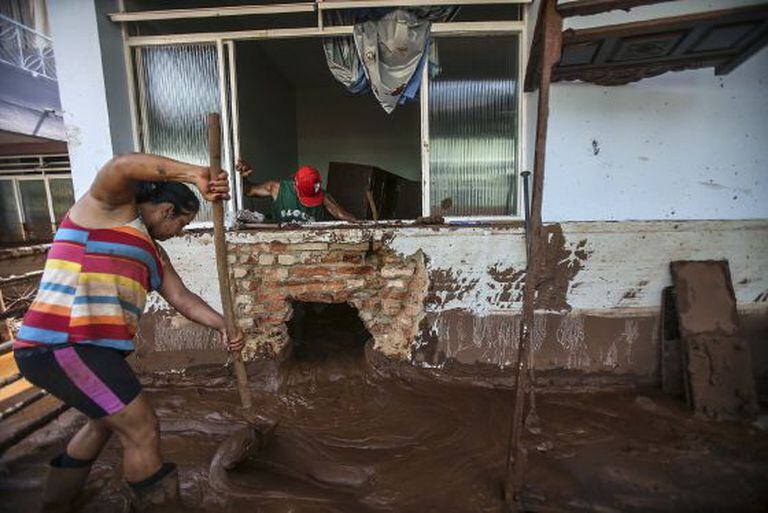Casal tenta limpar a casa em Barra Longa.