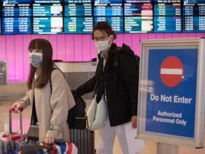 Passageiros com máscaras ao desembarcarem no aeroporto de Los Angeles, na quarta-feira.