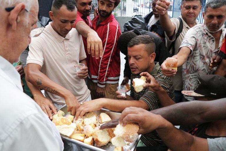 Pessoas em situação de rua recebem acolhimento e comida na paróquia São Miguel Arcanjo, na Mooca, zona leste de São Paulo.