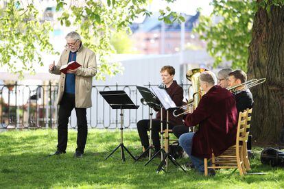 Músicos durante missa do Dia da Ascensão de Cristo nos jardins de uma igreja de Estocolmo.