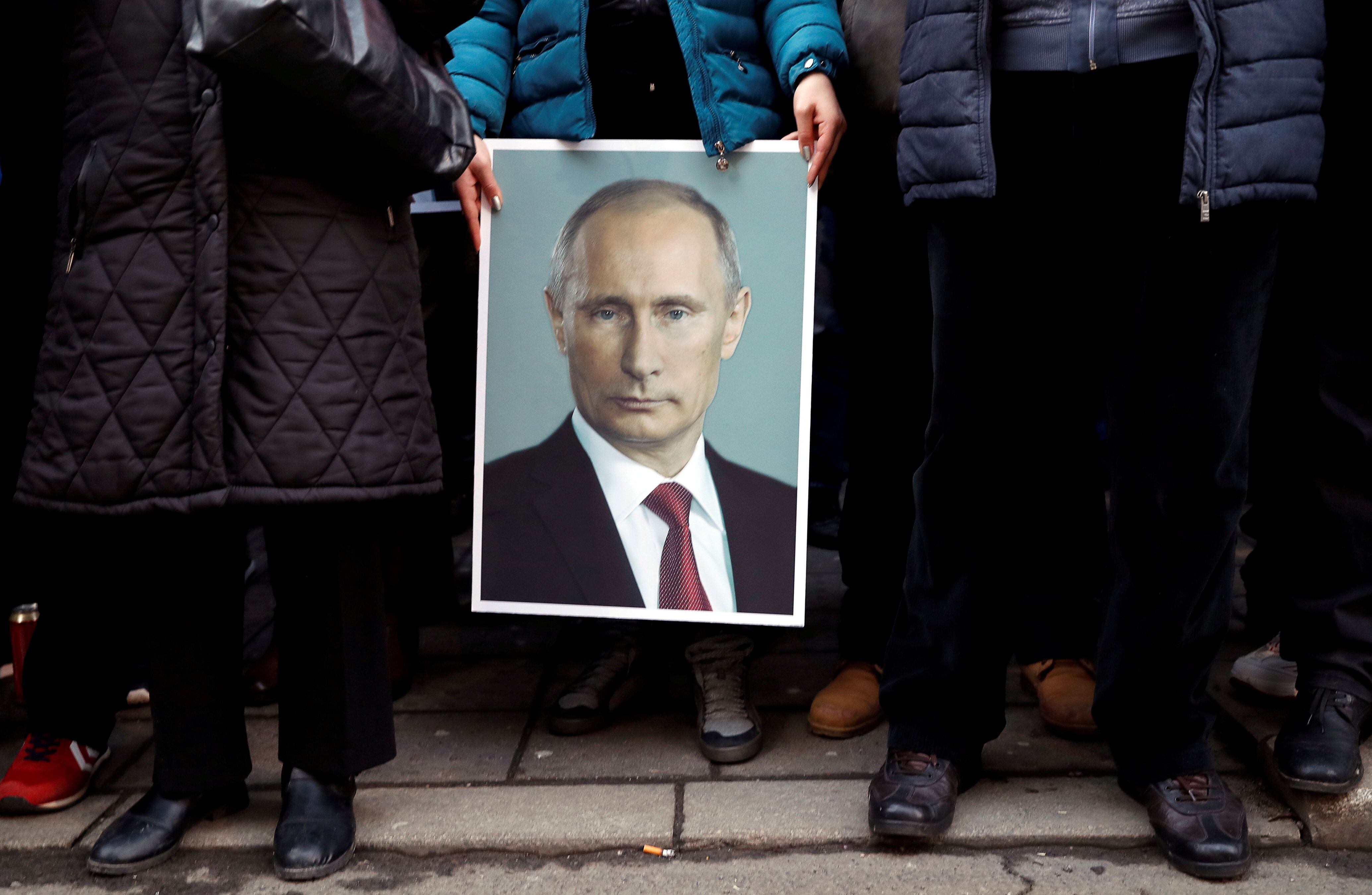 Um seguidor do presidente russo Vladimir Putin mostra um cartaz com sua imagem em Belgrado, na Sérvia, em 2019. 