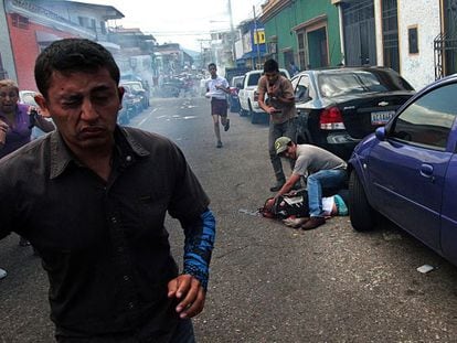 Um homem atende jovem baleado na segunda-feira durante um protesto em San Cristóbal, na Venezuela.