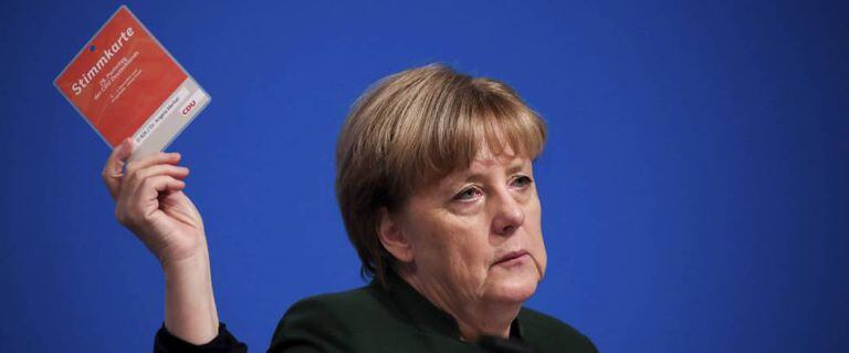 A chanceler alemã Angela Merkel levanta seu cartão de votação durante o Congresso Federal da CDU, em Essen.