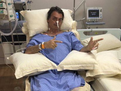 O candidato Jair Bolsonaro faz o famoso sinal de metralhadora para mostrar sua recuperação no hospital Albert Einstein de São Paulo.