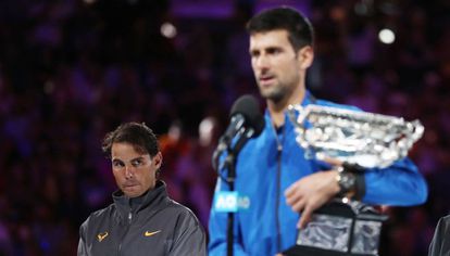 Nadal observa Djokovic durante a cerimônia de premiação em Melbourne.