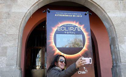 Turista faz selfie em frente a um mostrador com a contagem regressiva para o eclipse solar em Coquimbo (Chile).