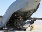 In this handout photo taken on June 16, 2021 and released on June 29, 2021 by the US Defense Visual Information Distribution Service (DVIDS) Aerial porters work with maintainers to load a UH-60L Blackhawk helicopter into a C-17 Globemaster III in support of the Resolute Support retrograde mission in Bagram. (Photo by Sgt 1st Class Corey Vandiver / DVIDS / AFP) / RESTRICTED TO EDITORIAL USE - MANDATORY CREDIT "US Defense Visual Information Distribution Service /  " - NO MARKETING - NO ADVERTISING CAMPAIGNS - DISTRIBUTED AS A SERVICE TO CLIENTS