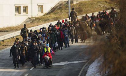 Um grupo de refugiados cruza a fronteira entre Eslovênia e Áustria, na sexta-feira passada.