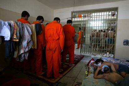 Prisioneiros iraquianos rezando em sua cela na prisão de Abu Ghraib, nos arredores de Bagdá, em 2004.