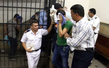 Os acusados escondem o rosto após a condenação no Cairo.