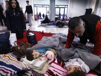 Migrantes descansam em edifício do porto vizinho a Atenas.