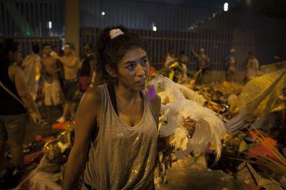 Uma mulher entre os restos das fantasias usadas para o desfile.