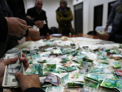 Palestinos contam o dinheiro arrecadado para reconstruir as casas de familiares de terroristas.