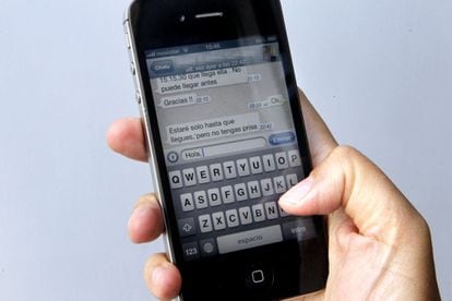 Uma usuária de Iphone envia uma mensagem por WhatsApp.