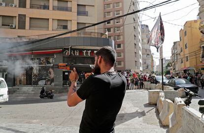 Um homem dispara sua arma no bairro de Tayuné durante os confrontos desta quinta-feira no Líbano.