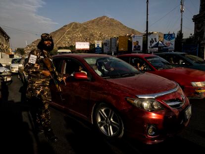 Soldado da milícia controla o tráfego na rotatória onde o Talibã exibe os supostos ladrões.