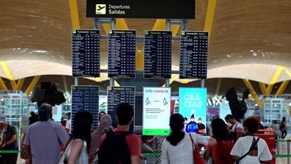 Passageiros observam informações sobre voos no terminal 4 do aeroporto Adolfo Suárez, em Madri, neste domingo.