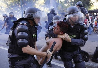Policiais detêm um manifestante neste domingo, no Rio.