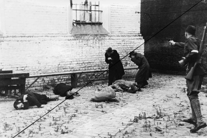 Um paramilitar letão assassina judeus em uma rua de Riga, em julho de 1941. A invasão nazista da URSS representou o início do assassinato maciço dos judeus europeus. 