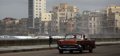 Um carro velho circula por Havana.