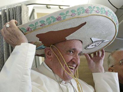 No avião, o papa Francisco brinca com o chapéu mexicano que ganhou de uma jornalista.