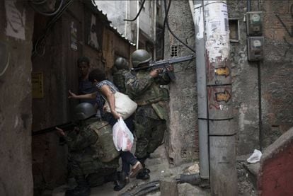 Moradora entra em viela durante incursão policial na favela da Rocinha, no Rio de Janeiro.
