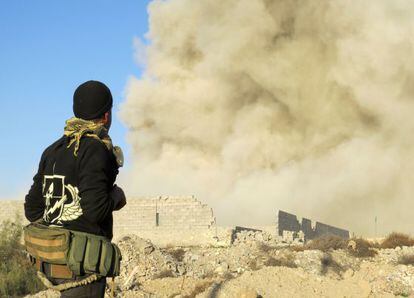 Um combatente pró-governo observa uma coluna de fumaça em um bairro de Ramadi hoje durante a ofensiva do Exército.