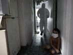 A kid looks on as a municipal healthcare worker walks after examining the body of Shirlene Morais Costa, who died at home at the age of 53 after reporting symptoms consistent with COVID-19, amid the coronavirus disease (COVID-19) outbreak in Manaus, Brazil, January 11, 2021. Picture taken January 11, 2021. REUTERS/Bruno Kelly