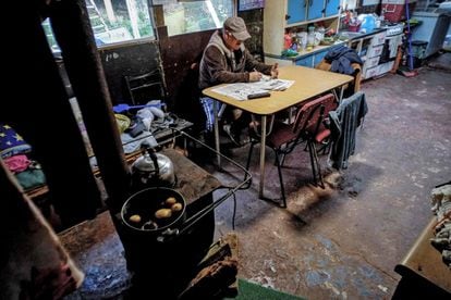 Um homem de 63 anos se senta na cozinha de sua casa no acampamento Pedro del Río Zanartu em Concepción, Chile.