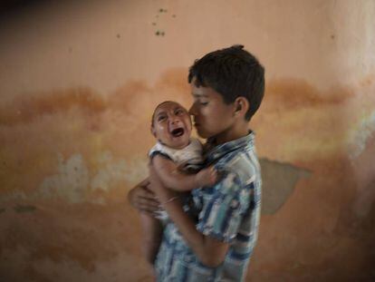 Elison, 10, segura o irmão José, 2 meses, que nasceu com microcefalia.