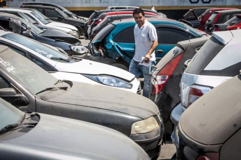 Consumidor analisa carros em pátio de leilão público em Guarulhos.