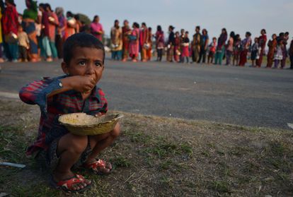Uma criança come arroz em um campo de refugiados nepalíes.