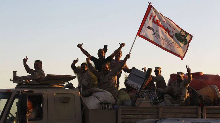 Soldados iraquianos festejam sobre seu veículo ao entrarem em Kirkuk nesta terça-feira