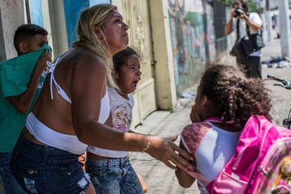 Crianças choram após inalarem gás lacrimogêneo no confronto.