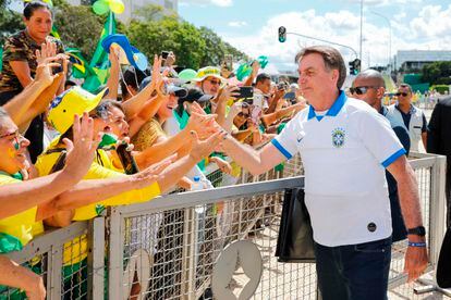Bolsonaro, que deveria estar em isolamento por ter tido contato com infectados com coronavírus, cumprimenta e toca apoiadores em Brasília.