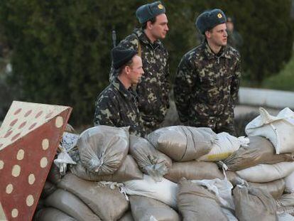Soldados ucranianos se protegem atrás de sacos de terra na base de Belbek, próximo a Sebastopol.