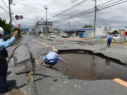 Policial examina cratera aberta pelo terremoto em uma rua de Takatsuki, ao norte de Osaka, na manhã desta segunda-feira