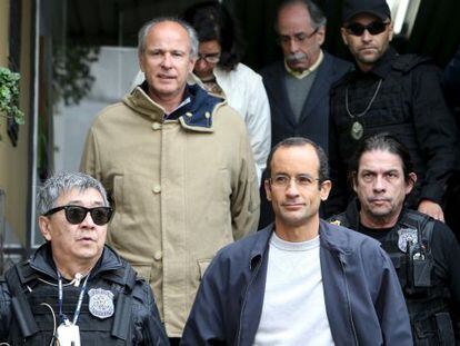 Os empreiteiros Marcelo Odebrecht (de óculos) e Otávio Marques Azevedo escoltados por policiais, em Curitiba.