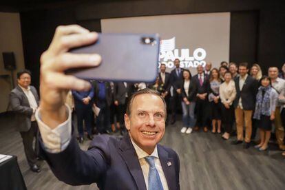 O governador João Doria tira selfie com os correspondentes.