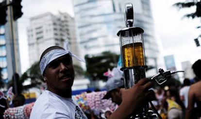Folião leva cerveja em uma mini bomba de gasolina, sábado em São Paulo.