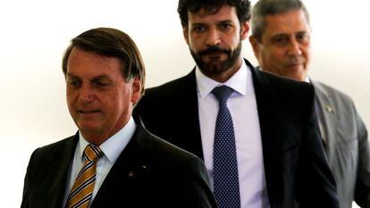 Presidente Jair Bolsonaro, acompanhado pelos ministros do Turismo, Marcelo Álvaro Antônio (C), e da Casa Civil, Braga Neto, durante o lançamento da retomada do turismo no Palácio do Planalto, em 10 de novembro.