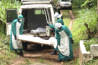 Sanitaristas transportam o corpo de uma vítima do ebola, em junho, em Kenema, Serra Leoa.