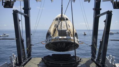 Cápsula da Crew Dragon, da SpaceX, é resgatada com os dois astronautas por embarcação após pouso no domingo.