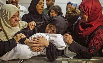 Mulher palestina abraça nesta terça sua filha de oito meses, morta nos confrontos com Israel na Faixa de Gaza.